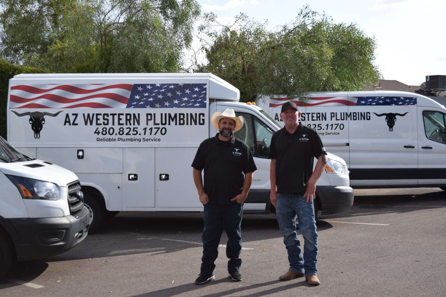 Two AZ Western Plumbing & Air team members beside company service vehicles